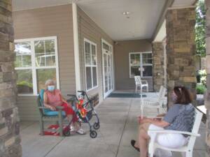 two women sitting on chairs, six feet apart