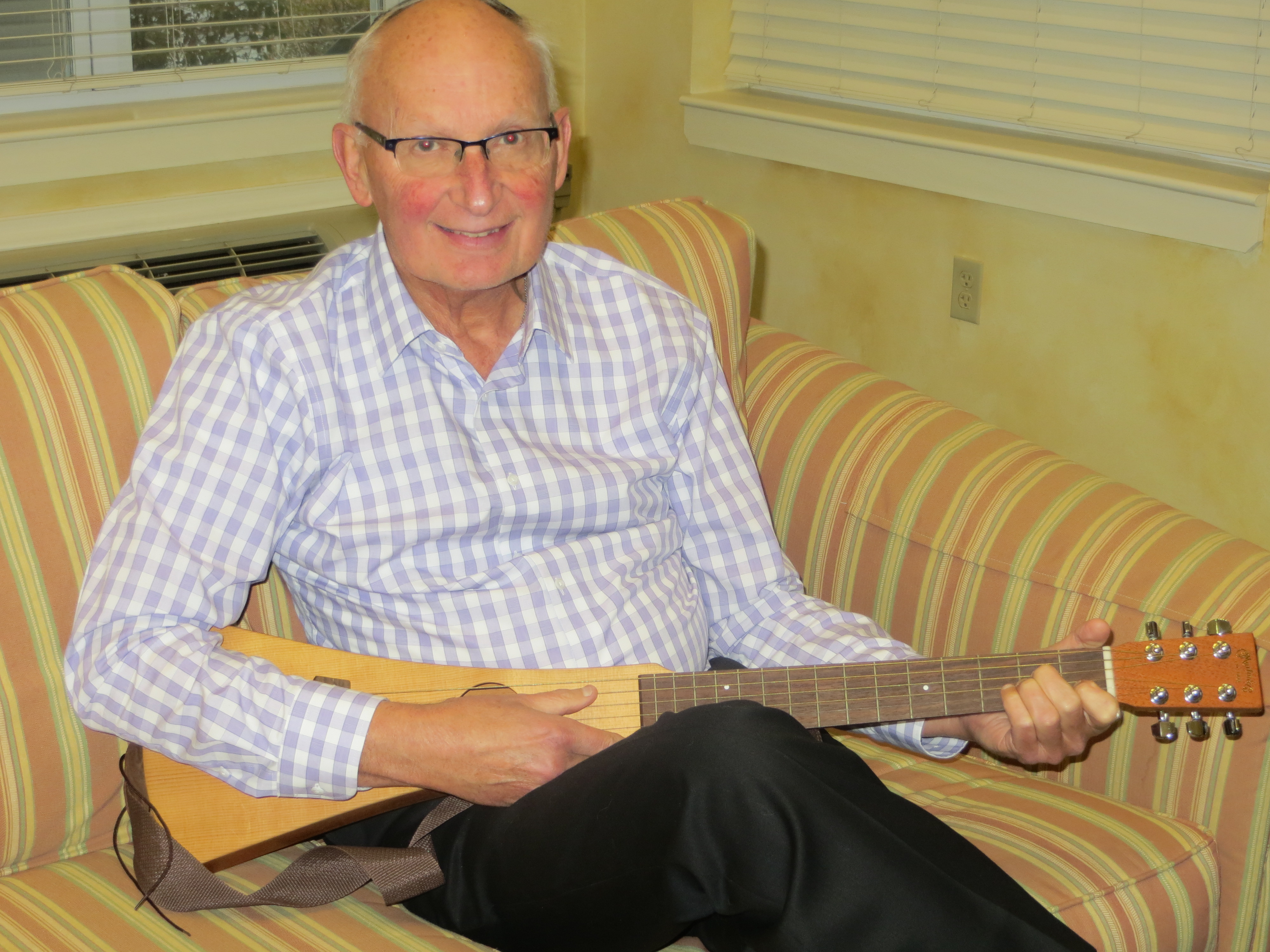 man sitting down, holding string instrument